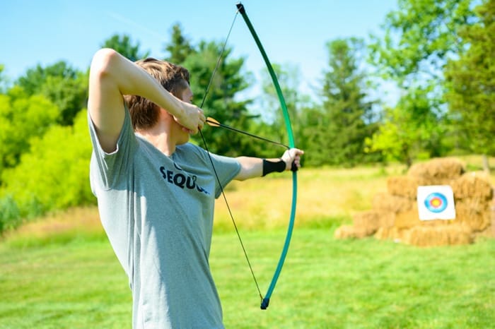 Older camper shooting archery arrow
