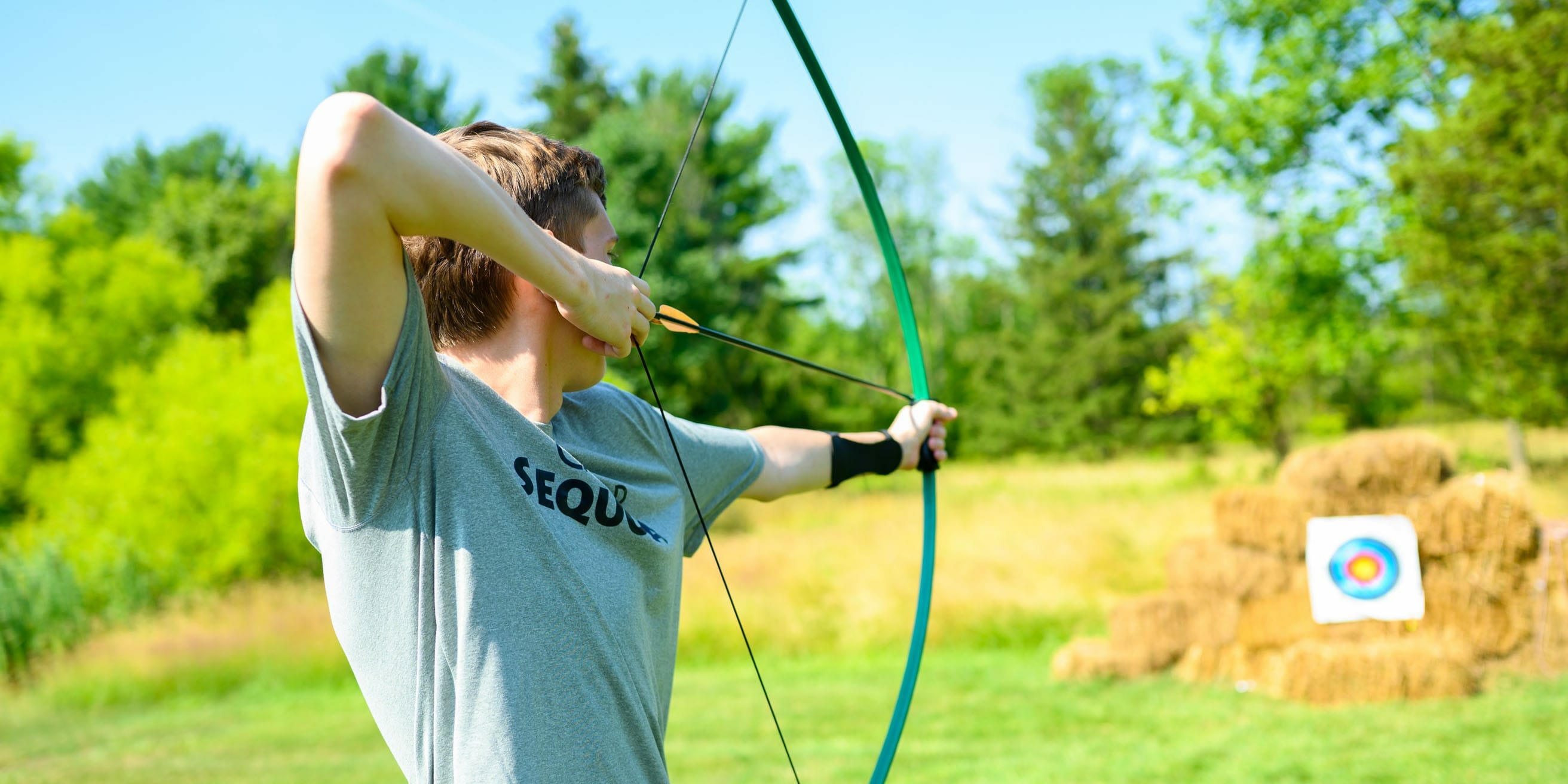 Older camper shooting archery arrow