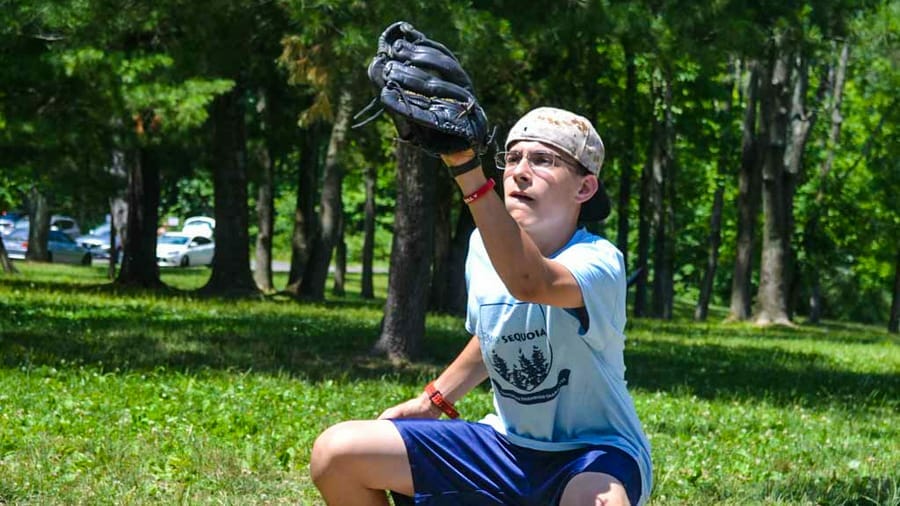 Boy with baseball glove catching the ball