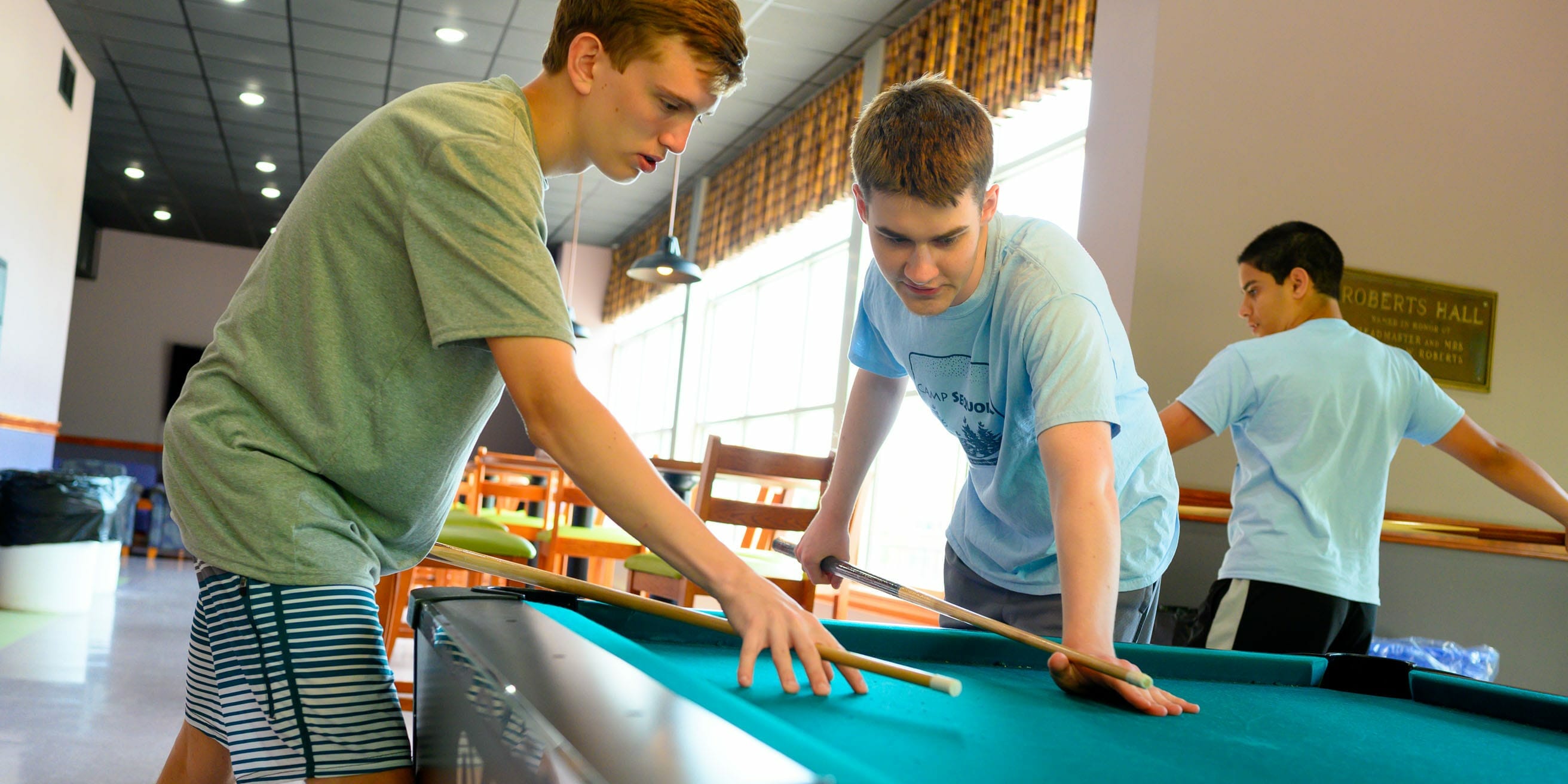 Two boys playing billiards