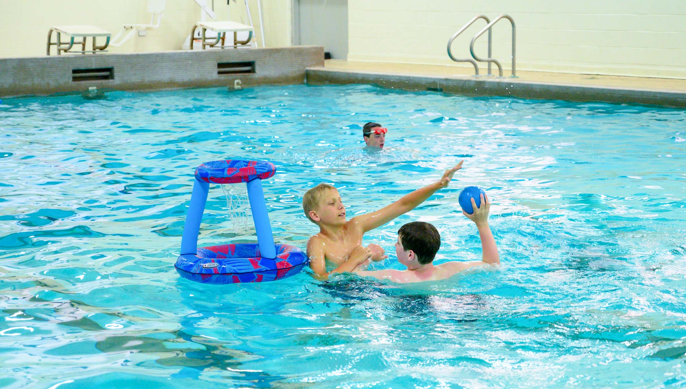 Boy swimming in the pool and playing games
