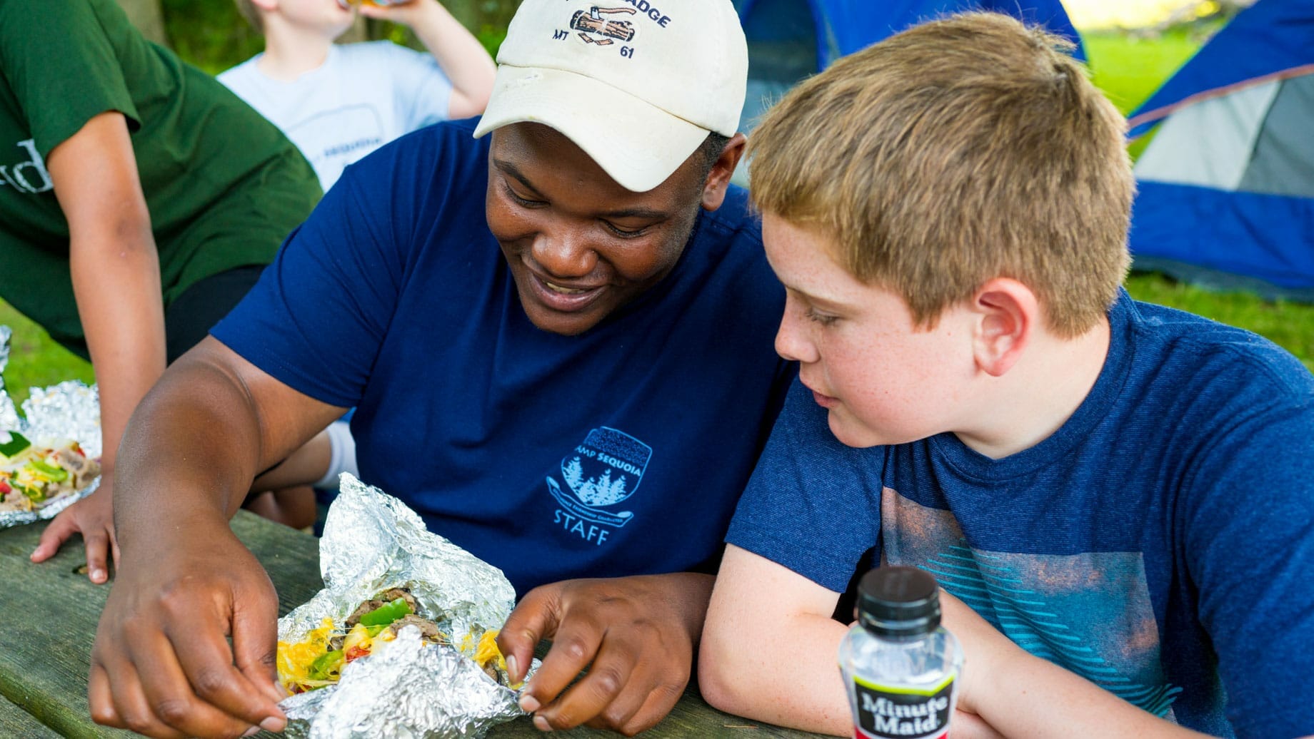 Staff and camper at outdoor cooking