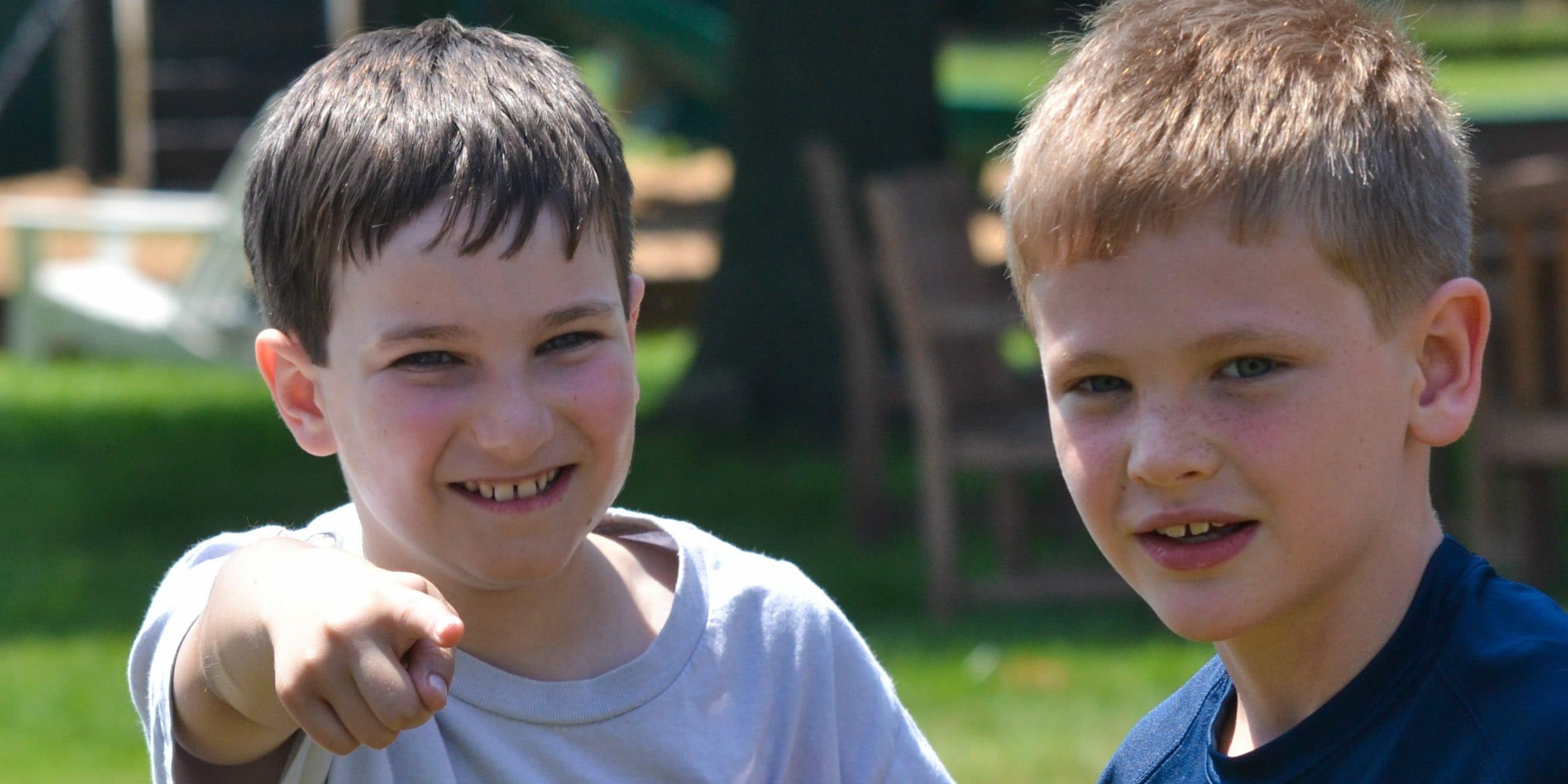 Two young campers, one of which is pointing towards camera