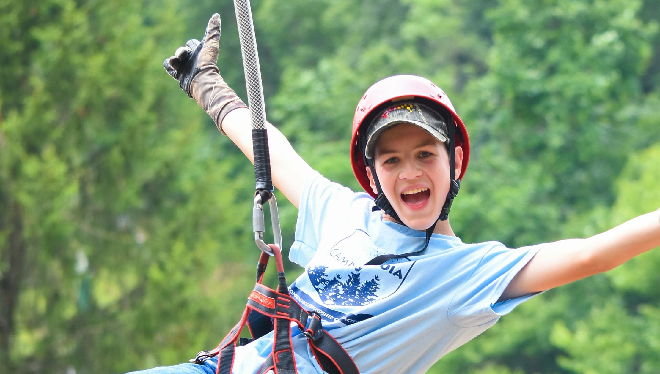 Boy zip lining with arms out