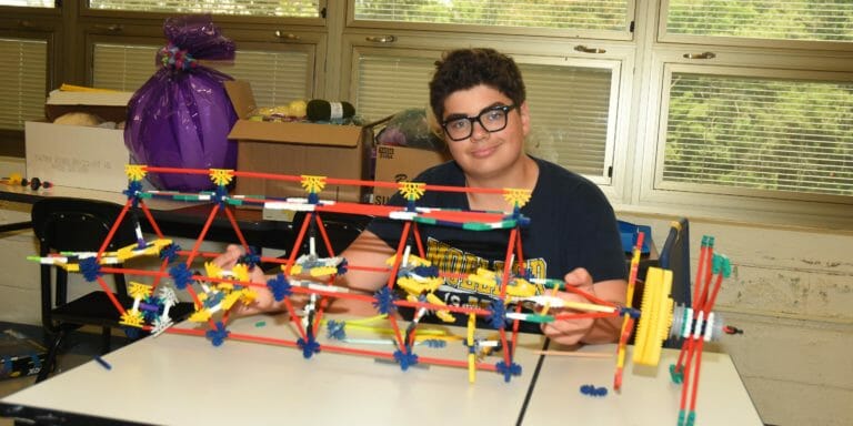 Camper smiling with his STEM project